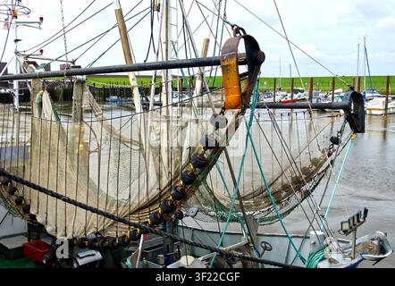 Garnelenfischerei-Boot mit Netzen, die am Takelwerk hängen, im Hafen vertäut, repräsentativ für die maritime Fischereiwirtschaft Stockfoto