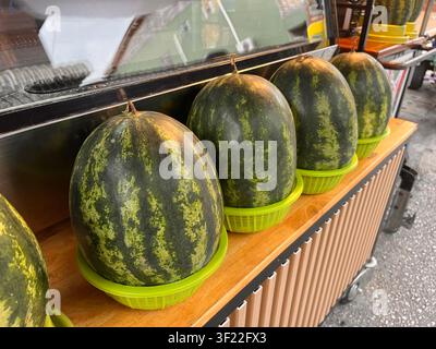 Frische Bio-Wassermelonen ordentlich auf einem Marktstand arrangiert. Stockfoto