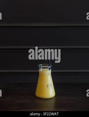 Frischer tropischer Mangosmoothie in einer Glasflasche serviert Stockfoto