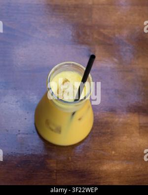 Frischer tropischer Mangosmoothie in einer Glasflasche serviert Stockfoto