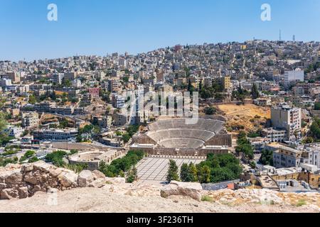 Erhöhte Ansicht des Römischen Theaters inmitten der dicht gedrängten Hügelstadtlandschaft von Amman, Jordanien. Stockfoto