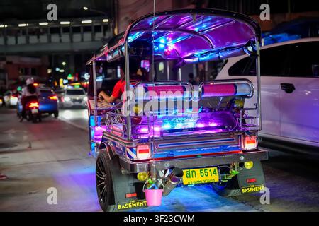 Bangkok Thailand: Angepasstes Tuk-Tuk-Autorickshaw mit hellen Neon-LED-Lichtern, die auf einer Straße der Stadt bei Nacht geparkt ist Stockfoto