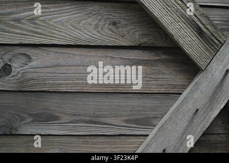 Verwitterte Holzplanken mit einem diagonalen Brettdetail in Nahaufnahme. Rustikale Holztexturhintergrund für Bau, Design, Möbel und Natur Stockfoto