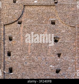 Eine hochwinklige Vollformat-Texturaufnahme einer alten Kirchenmauer in Catania, Sizilien, die fast vollständig aus wiederverwerteten historischen Steinen, Ziegeln und d Stockfoto