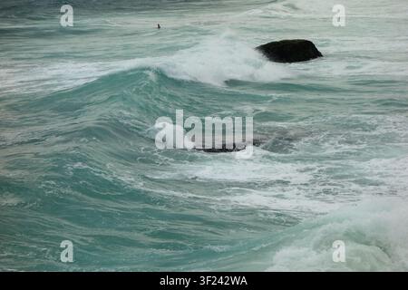 Ozeanwellen schlagen während des Sturms gegen Felsen an der Küste. Stockfoto
