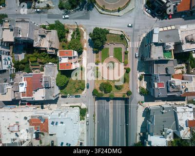 Luftbild von oben über Straßen, Gebäude, Verkehr und einen kleinen Stadtpark im Voulgari-Viertel von Thessaloniki, Griechenland. Stockfoto