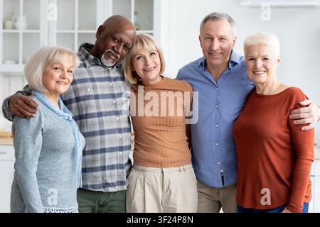 Glückliche multikulturelle Seniorengruppe lächelt zusammen in einer häuslichen Umgebung, Gemeinschaftskonzept Stockfoto