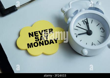 Konzept von Never Say Monday steht auf Klebezetteln isoliert auf Holztable. Stockfoto