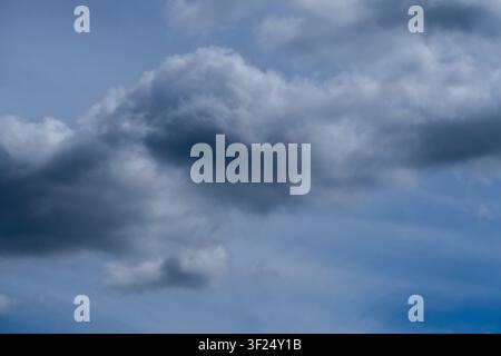 Dramatische dunkle Gewitterwolken bilden sich im blauen Himmel vor dem Regen Stockfoto