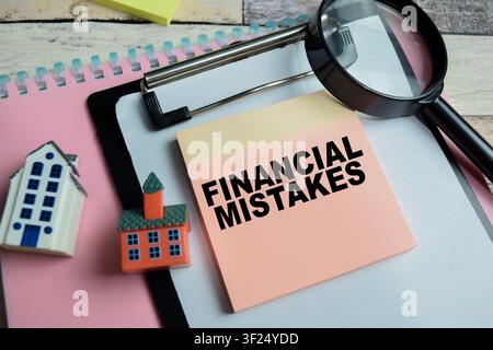 Konzept von finanziellen Fehlern, geschrieben auf Klebezetteln, isoliert auf Holztablett. Stockfoto