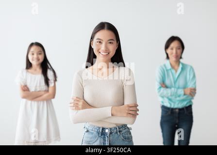 Lächelnde asiatische Frau steht selbstbewusst vor Freunden, positives Gruppenumfeld Stockfoto