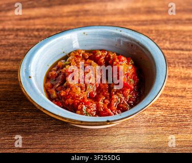 Traditionelle türkische Patlıcan Salatası mit gebratener Aubergine, Tomaten, Paprika und Olivenöl in einer Keramikschüssel. Stockfoto