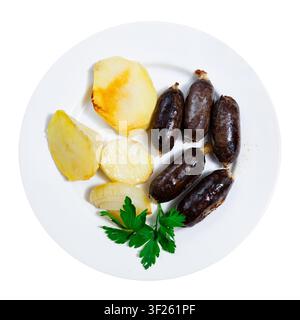 Mehrere kleine Puddings Würstchen werden mit Zwiebelringen gebraten geröstet Stockfoto