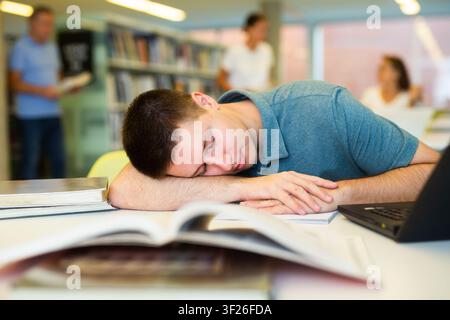 Porträt eines schlafenden jungen Studenten in der öffentlichen Bibliothek Stockfoto