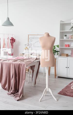 Schneidersarbeitsplatz mit Mannequin in einem stilvollen Atelier Stockfoto