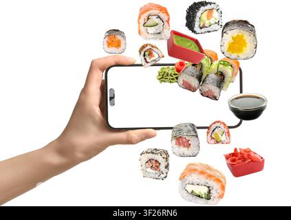 Hand, die ein Smartphone hält, mit verschiedenen Sushi-Rollen und Beilagen, die herausfliegen, Online-Bestellung und Lieferung von Speisen Stockfoto