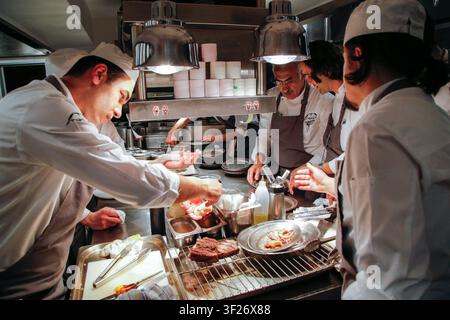 Caption Köche bereiten und garnieren Gerichte in einer professionellen Restaurantküche während eines Food-Festivals in Istanbul, Türkei, am 25. April 2016. Stockfoto