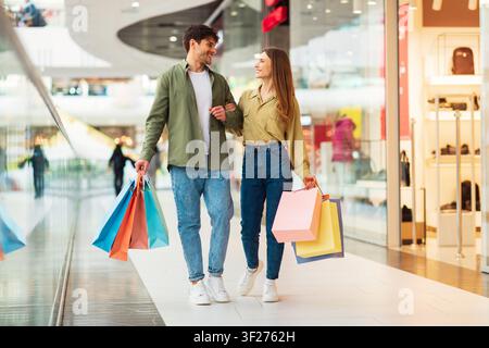 Glückliches Junges Paar, Das Zusammen In Der Mall Mit Bunten Einkaufstaschen Einkauft Stockfoto