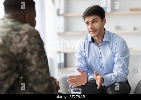 Junger kaukasischer männlicher Therapeut hört Patienten im Büro zu, Gesundheitskonzept Stockfoto