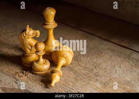 Alte hölzerne Schachfiguren. Antikes Schach auf einer Oberfläche aus rauem Holz. Stockfoto