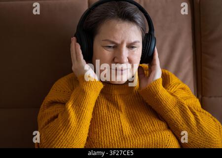Seniorin entspannt und hört Musik mit Kopfhörern Stockfoto