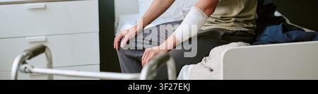 Kopfzeile von Mann, der während der Genesung nach einer Militärverletzung auf einem Krankenhausbett sitzt Stockfoto