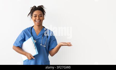 Lächelnde schwarze Krankenschwester hält Klemmbrett und Pillen in der Klinik, Gesundheitskonzept Stockfoto