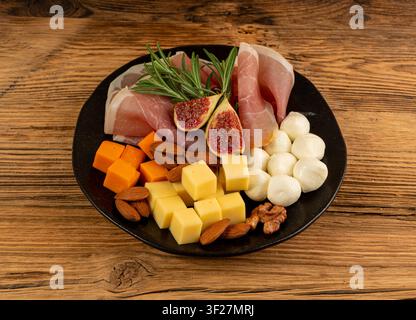 Käseplatte mit Prosciutto, Jamon-Schnitt, Parmaschinken, trockenen Serrano-Scheiben, gereiftem Iberico, Käsebrett, verschiedenen gehackten Milchprodukten, viele Sti Stockfoto