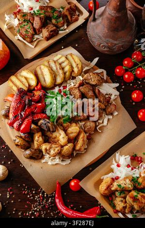 Rustikales Festmahl aus verschiedenen gegrillten Fleischsorten und Gemüsen Stockfoto
