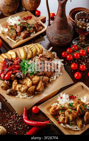 Ein rustikales Festmahl aus verschiedenen gegrillten Fleischsorten und Gemüse Stockfoto