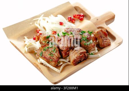 Saftiges gegrilltes Fleisch mit Zwiebeln und Granatapfel Stockfoto