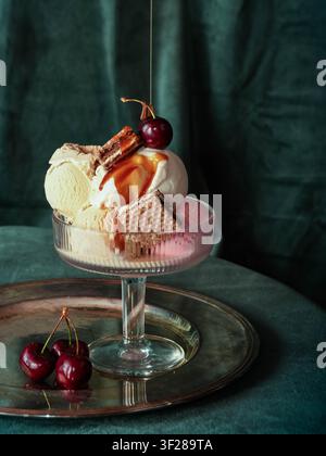 Gourmet-Eisbecher mit Karamellsoße und Kirschen Stockfoto
