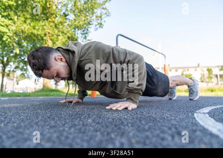 Junger Mann führt Liegestütze im Freien als Fitnesstraining durch Stockfoto