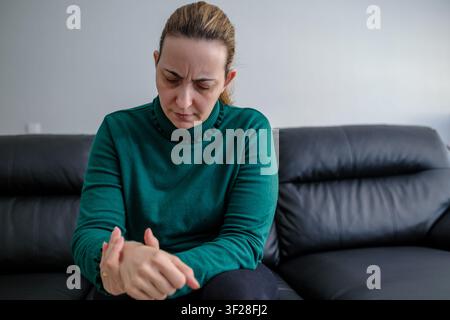 Frau mit Handgelenk- und Armschmerzen, Krankheitskonzept Stockfoto