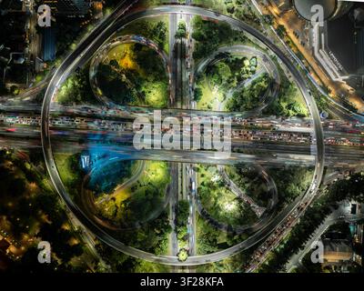 Luftaufnahme der beleuchteten Semanggi Interchange-Kreuzung bei Nacht mit starken Lichtspuren des Verkehrs und üppiger grüner Bepflanzung in Tanah Ab Stockfoto