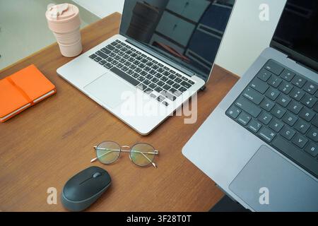 Moderne Schreibtischausstattung mit Laptop, Brille und Maus, minimaler Arbeitsbereich für Produktivität und Remote-Arbeit. Stockfoto