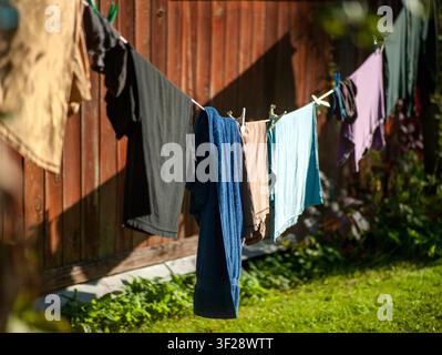 frisch gewaschene Wäsche trocknet am Seil im Hinterhof, Aufnahme an einem sonnigen Tag Stockfoto