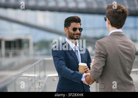 Verschiedene Geschäftsleute schütteln sich die Hände in einer Unternehmensbesprechung Stockfoto