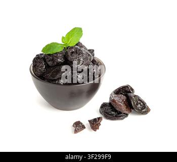Trockene Pflaumen isoliert, getrocknete schwarze Früchte in einer Schale, Pflaumengruppe, natürliches Dessert, gesunde Ernährung, trockene Pflaumenfrucht auf weißem Hintergrund Stockfoto