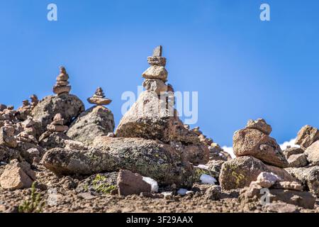 Unzählige Steinhaufen, die über die hochgelegene Mirador-de-los-Andes-Landschaft unter einem strahlend blauen peruanischen Himmel verstreut sind Stockfoto