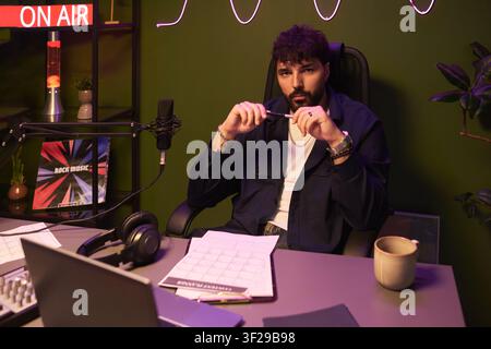 Porträt eines jungen Mannes, der einen Podcast in einem Aufnahmestudio hostet Stockfoto