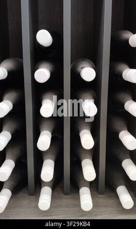 Dunkle Weinflaschen horizontal auf Holzregal gelagert Stockfoto