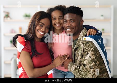 Glückliche afroamerikanische Familie zusammen zu Hause, lächelnd und sich umarmend Stockfoto