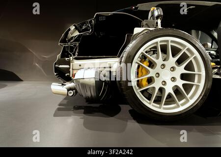 Eine Nahaufnahme-Schnittansicht eines modernen Sportwagenchassis, die sich auf das hintere Aluminiumrad, den Reifen und die Bremsscheibe konzentriert Stockfoto