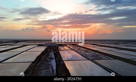 Dronansicht von Salzsiedeteichen bei farbenfrohem Sonnenuntergangshimmel Stockfoto