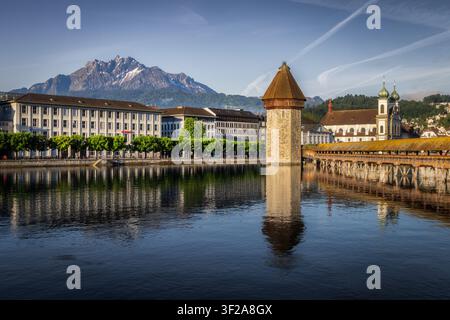 Blick auf die historische Kapellbrücke und den Wasserturm, die die Reuss überspannen, mit dem schneebedeckten Pilatus im Hintergrund in Luzern, Luzern Stockfoto