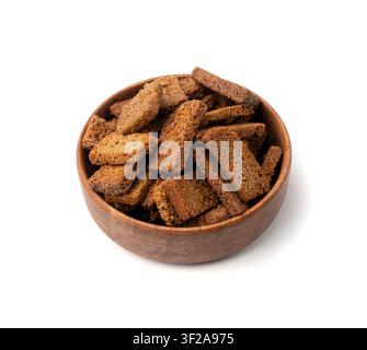 Roggencroutons in Holzschale isoliert, hausgemachte braune Brotrinden, knusprige Brotwürfel verstreuter Haufen, trockene Roggencrouton-Brösel, braune geröstete gesalzene Cracker Stockfoto