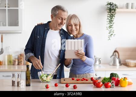 Glückliches gemischtrassiges Paar, das zu Hause zusammen ein Tablet benutzt, Familienkonzept Stockfoto