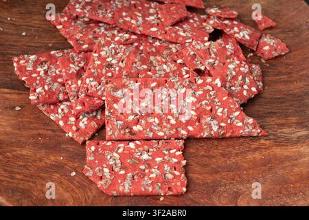 Rote-Bete-Kracker-Stücke, zerbröseltes dünnes Brot aus Rote-Bete-Ruske, zerbrochenes rotes Diät-Vollkornknäckebrötchen, verschiedene Samen-Vollkornknäckebrot, langes Knäckebrot Stockfoto