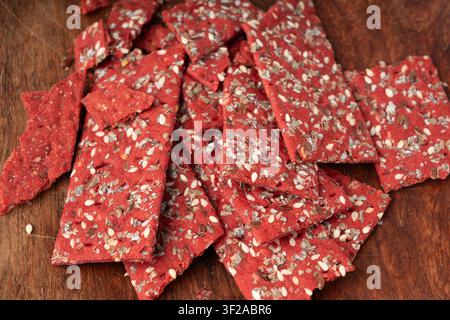 Rote-Bete-Kracker-Stücke, zerbröseltes dünnes Brot aus Rote-Bete-Ruske, zerbrochenes rotes Diät-Vollkornknäckebrötchen, verschiedene Samen-Vollkornknäckebrot, langes Knäckebrot Stockfoto